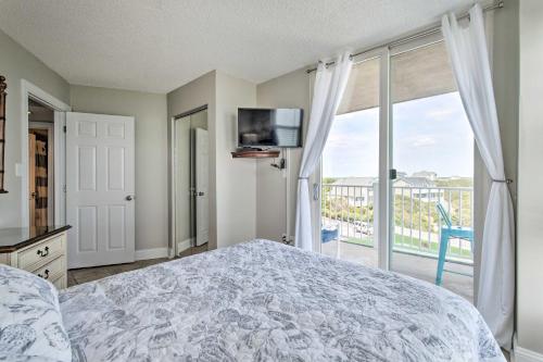 een slaapkamer met een bed en uitzicht op een balkon bij Relaxing Resort Retreat with Impeccable Ocean Views! in North Topsail Beach