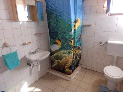 La salle de bains est pourvue d'un rideau de douche aquarium et d'un lavabo. dans l'établissement Apartments for families with children Kampor, Rab - 15144, à Rab