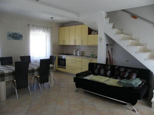 a living room with a black couch and a kitchen at Holiday house with a parking space Lumbarda, Korcula - 15165 in Lumbarda