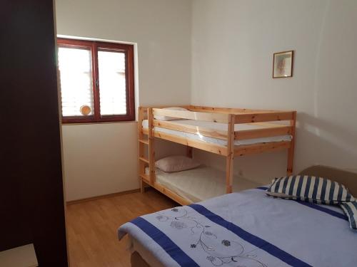 ein Schlafzimmer mit einem Etagenbett und einem Fenster in der Unterkunft Apartments by the sea Cove Koromasna, Zirje - 15166 in Žirje