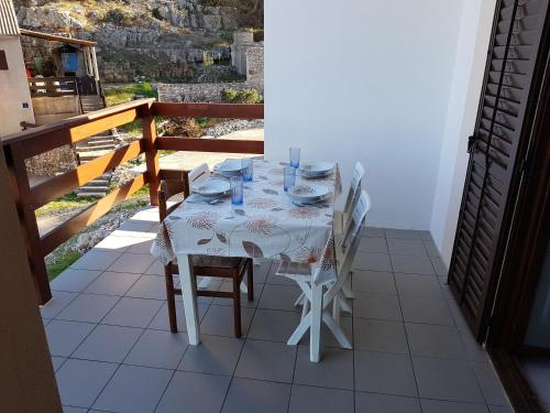 einen Tisch mit einem weißen Tischtuch auf dem Balkon in der Unterkunft Apartments by the sea Cove Koromasna, Zirje - 15166 in Žirje