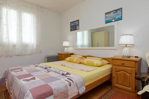 een slaapkamer met een bed en een spiegel aan de muur bij Apartments by the sea Pisak, Omis - 15177 in Mimice