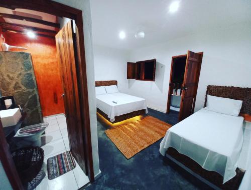 mały pokój z 2 łóżkami i lustrem w obiekcie Recanto pais e filho w mieście Monte das Gameleiras