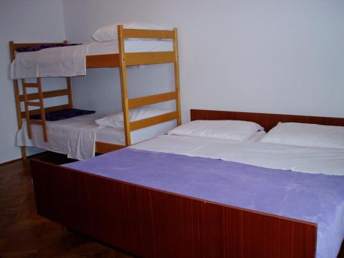 Dobrinj的住宿－Apartments with a parking space Tribulje, Krk - 15223，一间卧室配有两张双层床和蓝色床垫