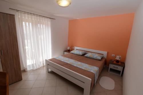 a bedroom with a bed and a large window at Apartments by the sea Veli Losinj, Losinj - 15229 in Veli Lošinj
