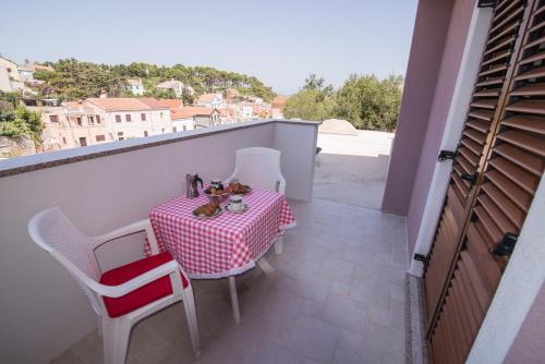 a table and chairs on a balcony with a view at Apartments by the sea Veli Losinj, Losinj - 15229 in Veli Lošinj