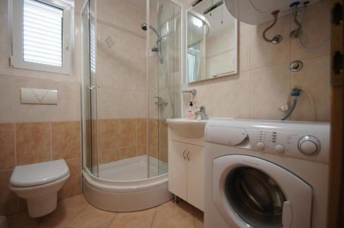 a bathroom with a washing machine and a shower at Apartments with a parking space Punat, Krk - 15231 in Punat