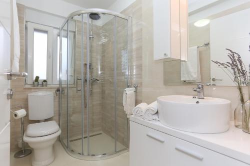 Un baño con ducha, inodoro y lavabo. en Apartments by the sea Tribunj, Vodice - 15233, en Tribunj