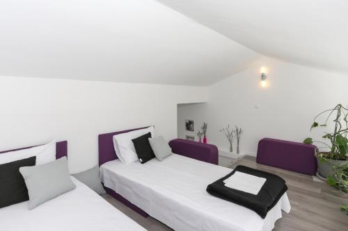 1 dormitorio con 2 camas y sillas moradas en Apartments by the sea Tribunj, Vodice - 15233, en Tribunj