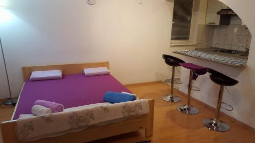 een slaapkamer met een paars bed en krukken bij Apartments with a parking space Senj - 15236 in Senj