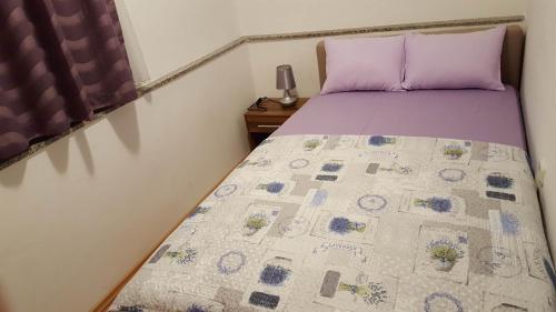 een slaapkamer met een bed met een quilt bij Apartments with a parking space Senj - 15236 in Senj