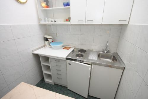 małą kuchnię ze zlewem i kuchenką w obiekcie Apartments with a parking space Makarska - 9696 w Makarskiej