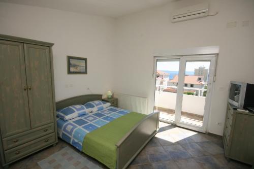 sypialnia z łóżkiem i przesuwnymi szklanymi drzwiami w obiekcie Apartments with a parking space Makarska - 9696 w Makarskiej