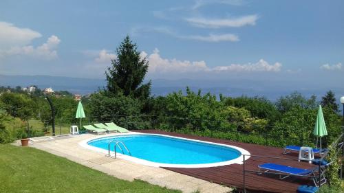 Veprinac的住宿－Family friendly apartments with a swimming pool Veprinac, Opatija - 14916，庭院内的游泳池,配有两把草坪椅