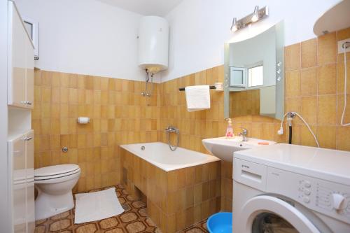 ein Badezimmer mit einem WC, einem Waschbecken und einer Waschmaschine in der Unterkunft Apartments with a swimming pool Mali Rat (Omis) - 9698 in Dugi Rat