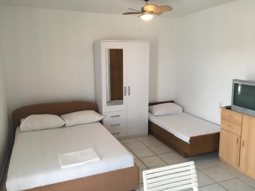 a small room with two beds and a tv at Apartment Stara Novalja 9368b in Novalja