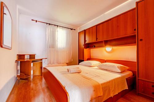 um quarto com uma cama grande e armários de madeira em Apartments by the sea Kneza, Korcula - 10168 em Racisce