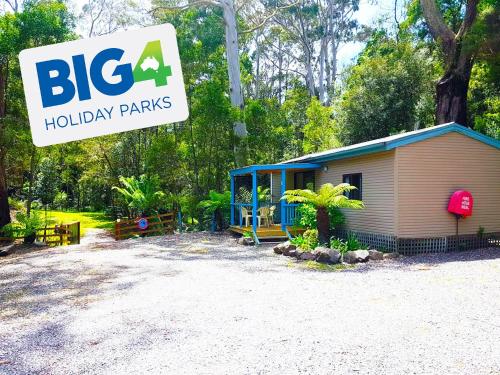 una pequeña casa con un cartel delante en BIG4 Strahan Holiday Retreat, en Strahan