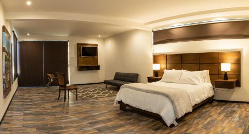um quarto de hotel com uma cama e uma cadeira em Estancias Sierravita em Valle de Guadalupe