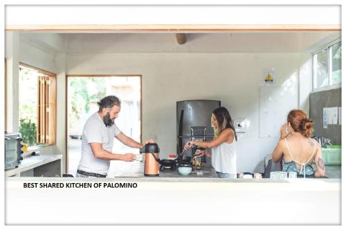 grupa ludzi w kuchni przygotowujących jedzenie w obiekcie Freesoul Hostel w mieście Palomino
