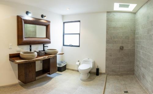 y baño con aseo, lavabo y espejo. en Estancias Sierravita, en Valle de Guadalupe
