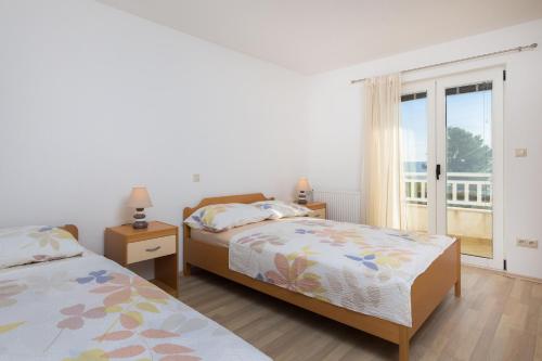 um quarto com 2 camas e uma janela com uma varanda em Apartments with a swimming pool Kastel Kambelovac, Kastela - 12073 em Kaštela