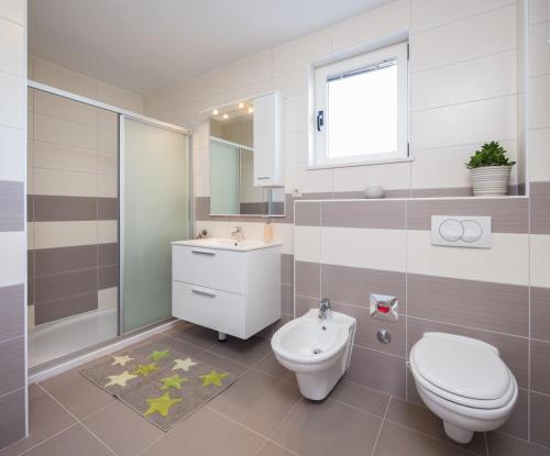 uma casa de banho com um WC branco e um lavatório. em Apartments with a swimming pool Kastel Kambelovac, Kastela - 12073 em Kaštela