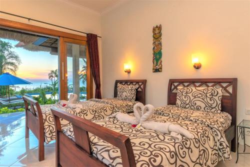 a bedroom with two beds and a view of the ocean at The North Cape Beach Villas in Umeanyar