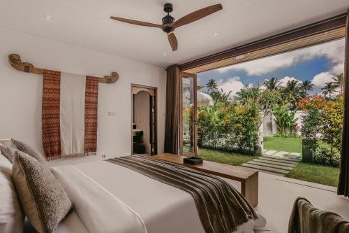 um quarto com uma cama e uma grande janela em Umah Shama em Ubud