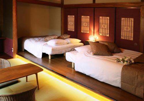 Habitación con 3 camas y mesa. en Osaka - House - Vacation STAY 8296, en Osaka