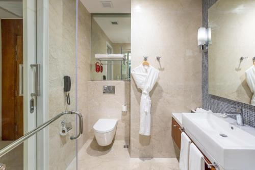 a bathroom with a sink and a toilet and a shower at Richmonde Hotel Iloilo in Iloilo City