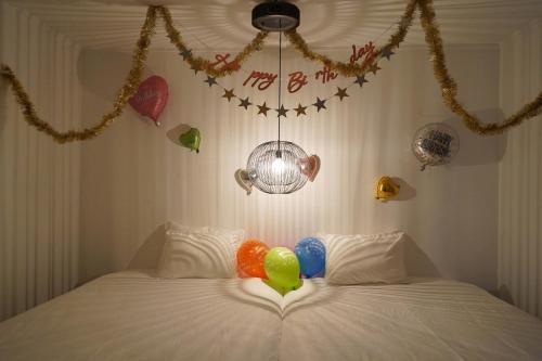 een slaapkamer met ballonnen op een bed met decoraties bij Transit House 5S Terminal in Chatan