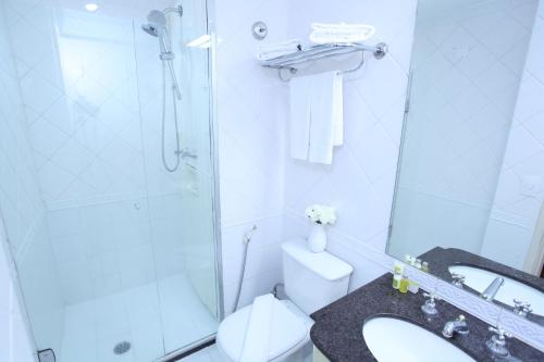 uma casa de banho com um chuveiro, um WC e um lavatório. em The World Vila Olímpia em São Paulo