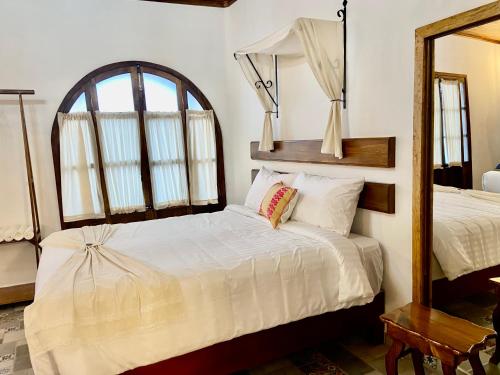 a bedroom with a bed and a mirror at Hotel Boutique Los Ángeles in Zacatlán