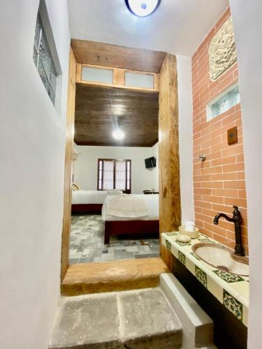 a bathroom with a sink and a bed in a room at Hotel Boutique Los Ángeles in Zacatlán