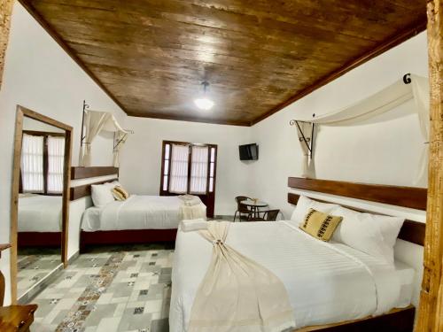 a bedroom with two beds and a table at Hotel Boutique Los Ángeles in Zacatlán