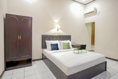 Tempat tidur dalam kamar di Urbanview Hotel Gading Kencana Samarinda by RedDoorz