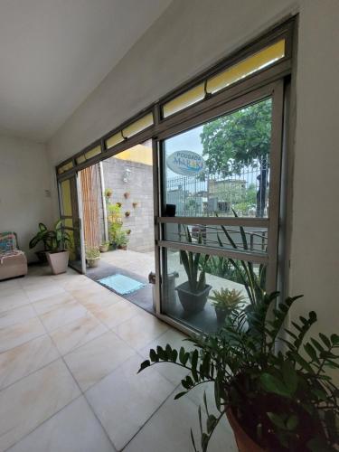 a large glass door in a room with potted plants at Pousada Maraki in Maceió