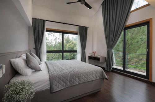 um quarto com uma cama e uma grande janela em Spring Moon Villa Tam Dao - Venue Travel em Làng Hạ