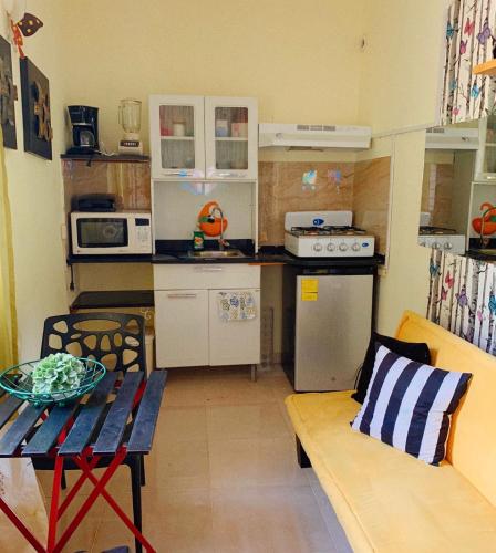 a small kitchen with a table and a bench in a room at Espectacular y Acogedor in Santo Domingo