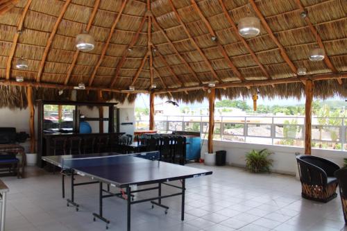 a ping pong table in a restaurant with a ceiling at Hotel & Suites VAYOR in San Patricio Melaque