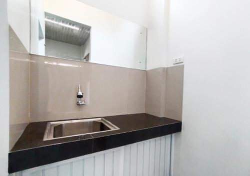 La salle de bains est pourvue d'un lavabo dans un mur blanc. dans l'établissement Hometown Residence, à Bandar Lampung