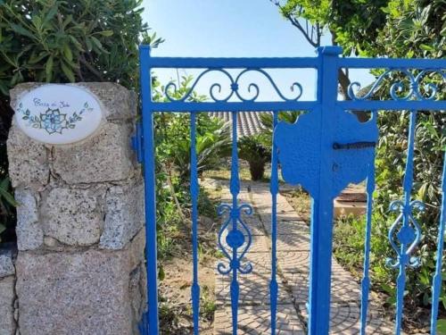 a blue gate to a garden with a sign on it at Appartamento Semi-Interrato Masi in Torre Dei Corsari