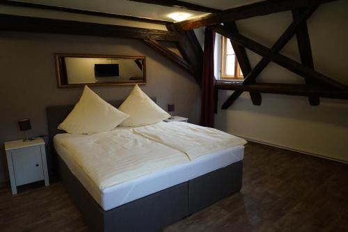 a bedroom with a bed with white sheets and a window at Kaufmannshaus Anno 1613 in Quedlinburg