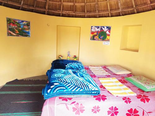 a bedroom with a bed with a blue and white blanket at Osian Dhana Ram Ki Dhani Home Stay Osian in Osiān