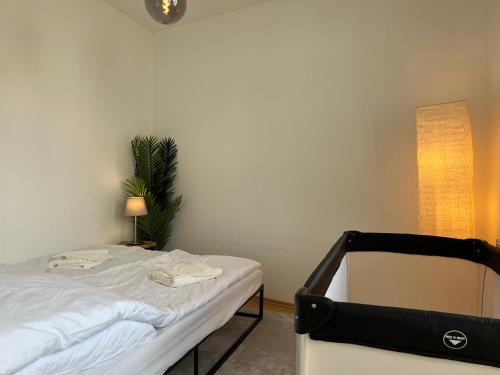 a bedroom with a bed and a plant and a lamp at Cozy-Livings viel Platz, großer Balkon, STELLPLATZ, Küche in Bad Homburg vor der Höhe