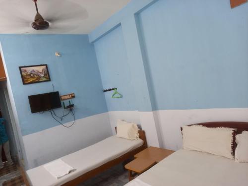 a small room with a couch and a tv at Parisha Residency- Temple Side Hotel in Chidambaram