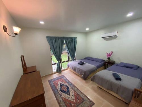 una camera con due letti e una finestra di Villa Teratai 878 @ A'Famosa Resort a Kampong Alor Gajah
