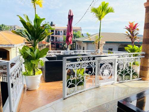 a balcony with a white railing and palm trees at Residence Seka in Mbalngong