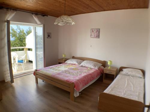 - une chambre avec un lit et une porte coulissante en verre dans l'établissement Apartments by the sea Lun, Pag - 9395, à Lun